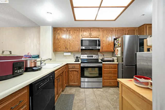 a kitchen with stainless steel appliances granite countertop a stove top oven a sink and a microwave