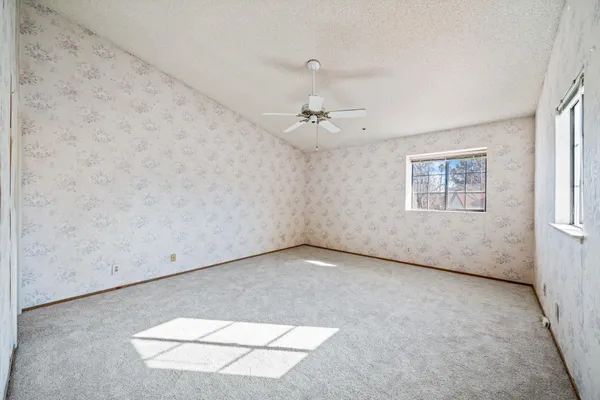 an empty room with a ceiling fan and a window