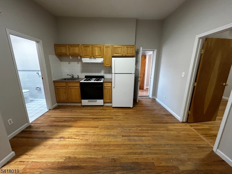 26 Ferry Street Newark, NJ 07105 - Photo 5 of 16 a view of a refrigerator in kitchen and an empty room