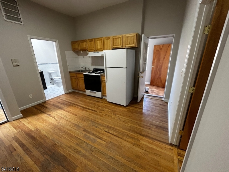 26 Ferry Street Newark, NJ 07105 - Photo 6 of 16 a kitchen with a refrigerator and wooden floor