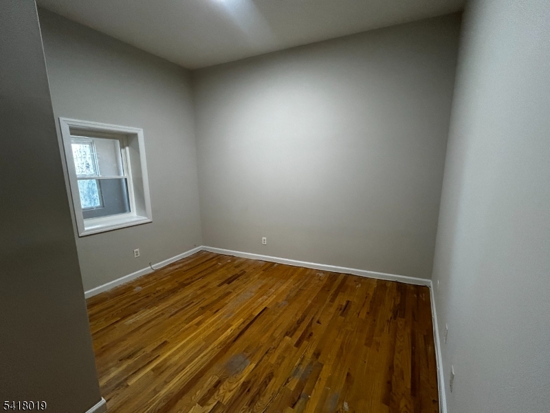 26 Ferry Street Newark, NJ 07105 - Photo 8 of 16 an empty room with wooden floor and windows