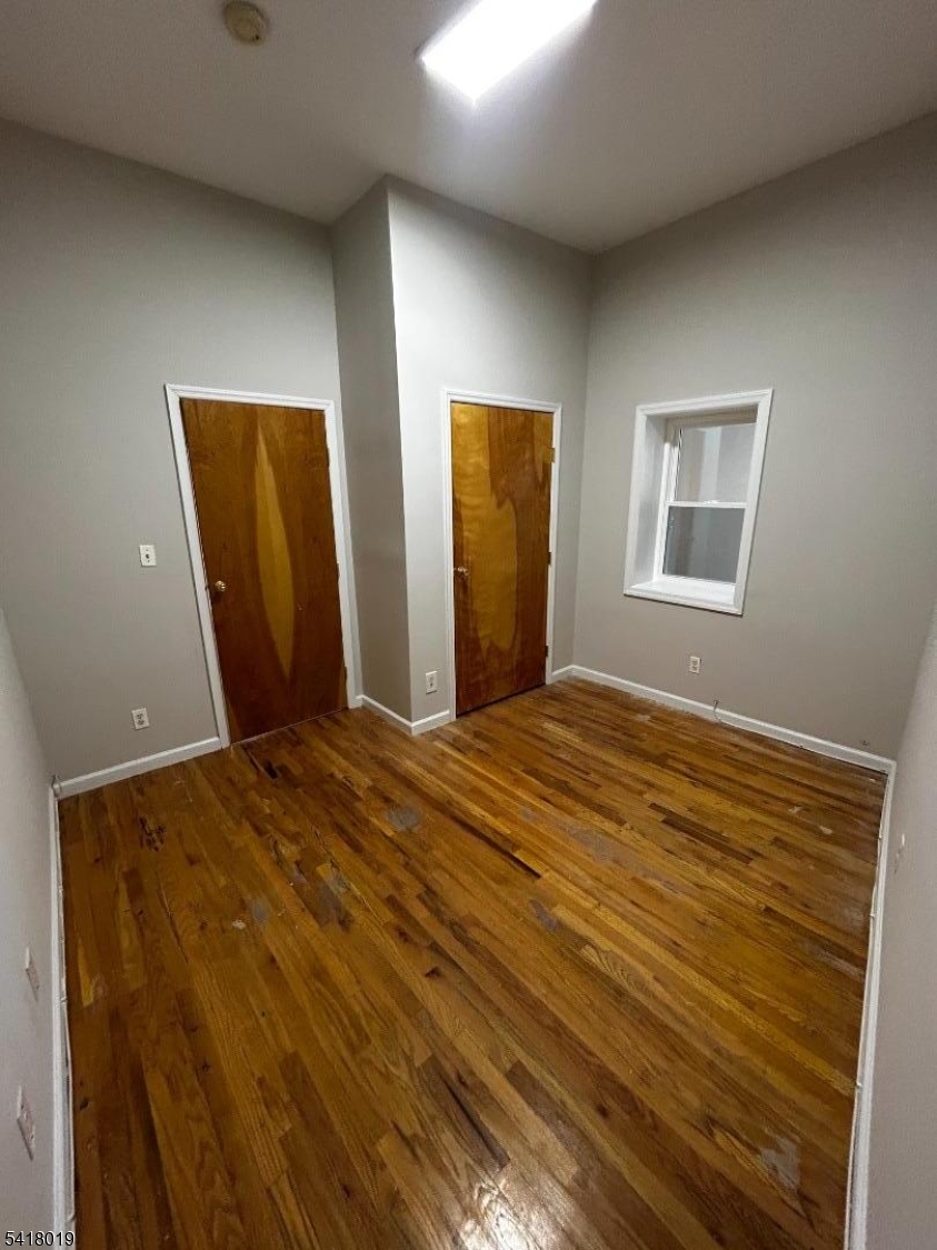 26 Ferry Street Newark, NJ 07105 - Photo 9 of 16 a bedroom with a bed and wooden floor