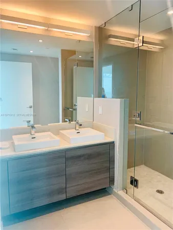 a bathroom with a tub a sink and mirror