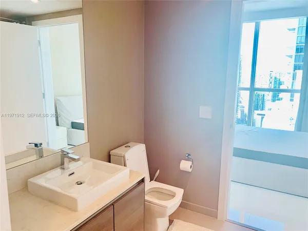a bathroom with a sink a toilet and a mirror