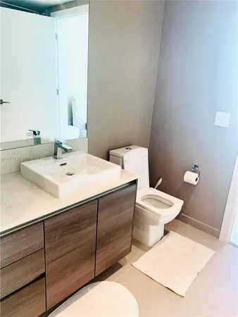 a bathroom with a sink mirror and toilet