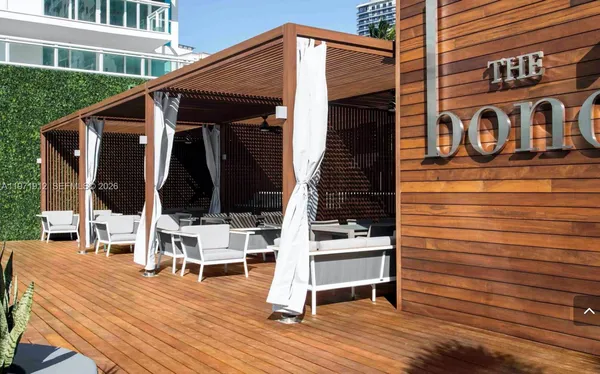 a view of house with wooden deck and furniture
