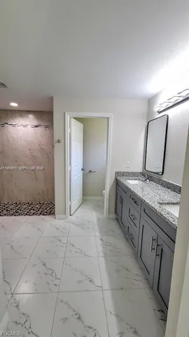 a spacious bathroom with a granite countertop sink a toilet and mirror