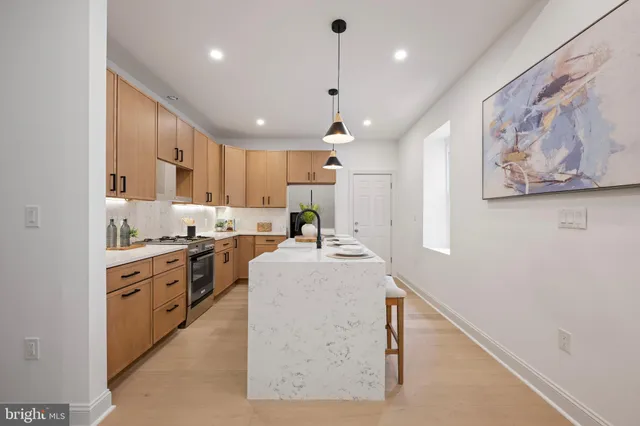 a large white kitchen with kitchen island a stove a sink a refrigerator and a cabinets