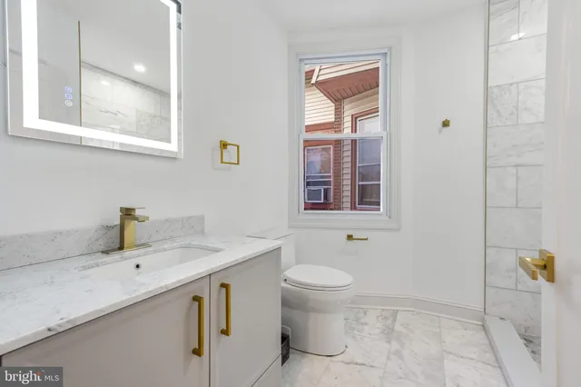 a bathroom with a sink toilet and mirror