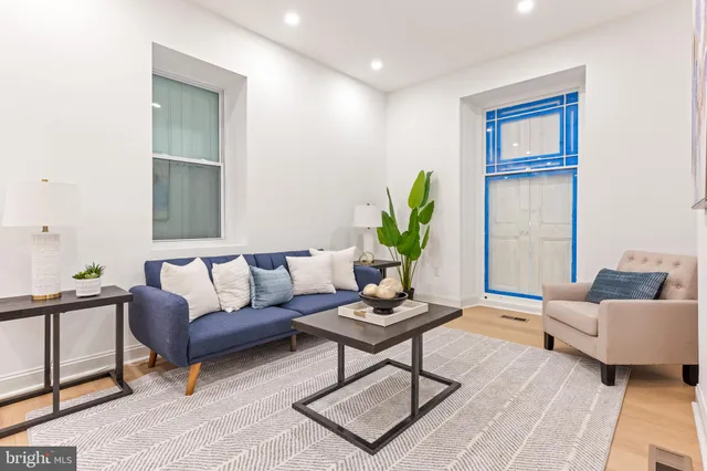 a living room with furniture and a potted plant