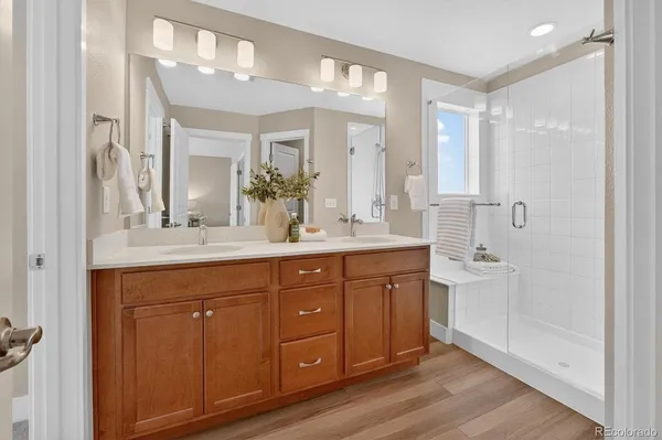 a bathroom with a double vanity sink and mirror with shower