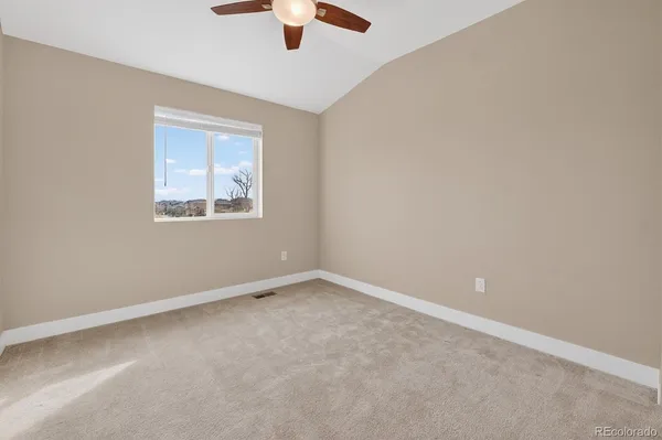 an empty room with a window and a ceiling fan