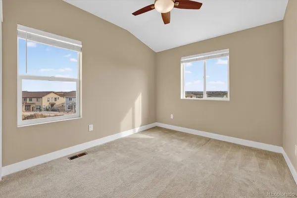 an empty room with windows and fan