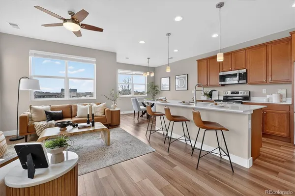 a living room with stainless steel appliances kitchen island granite countertop furniture a rug a stove and a kitchen view