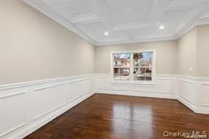 a open kitchen with kitchen island a stove a sink a refrigerator and white cabinets with wooden floor