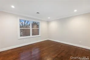an empty room with wooden floor and a window