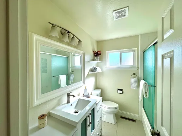 a bathroom with a toilet a sink and mirror