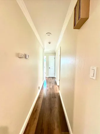 a view of a hallway with wooden floor