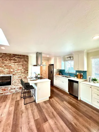 a kitchen with a sink a counter top space and living room area