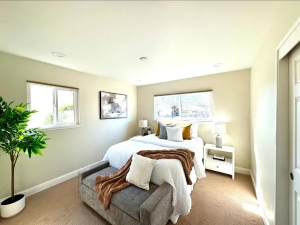 a bedroom with a bed and a potted plant