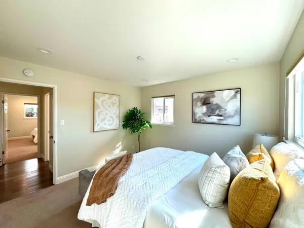 a bedroom with bed and a painting on the wall