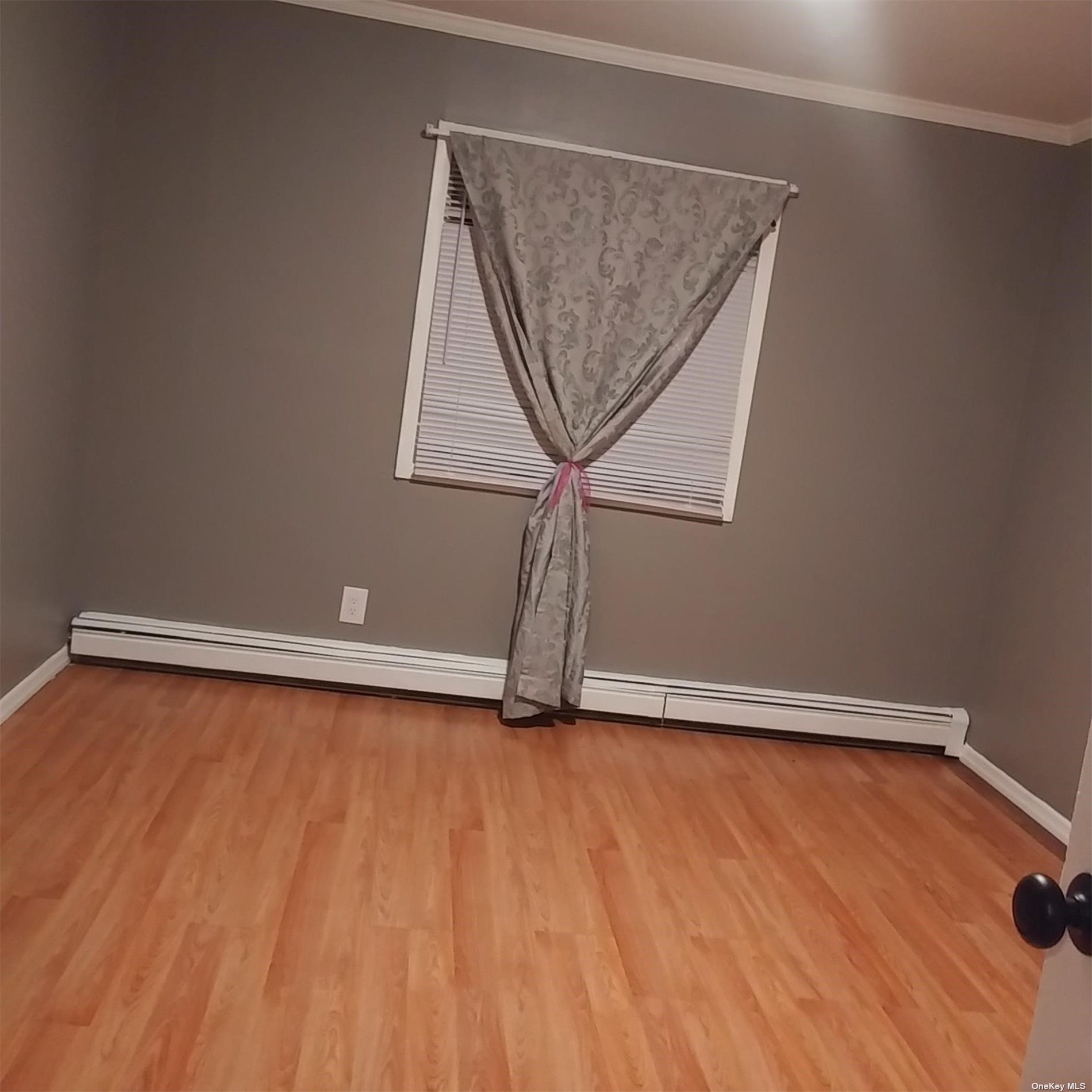 an empty room with a wooden floor and a window