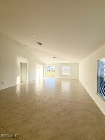 a room with stainless steel appliances kitchen island granite countertop a sink and cabinets