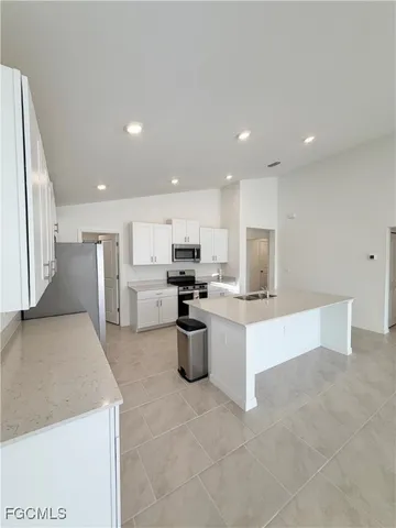 a kitchen with white cabinets and stainless steel appliances