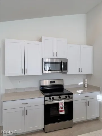a large kitchen with stainless steel appliances and a refrigerator