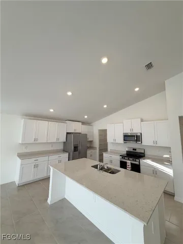a view of kitchen with refrigerator sink and stove