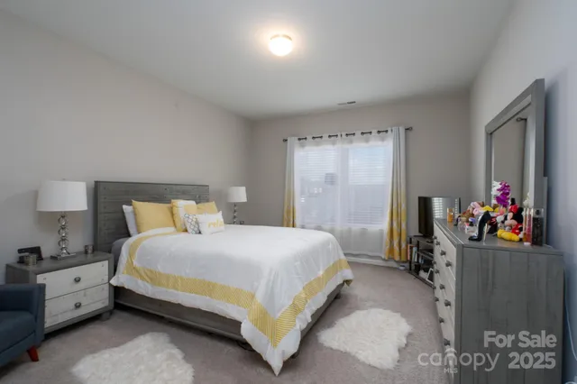 a spacious bedroom with a bed and a lamp