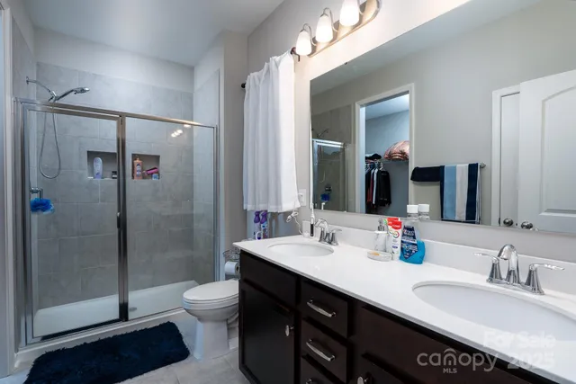 a bathroom with a double vanity sink toilet and shower