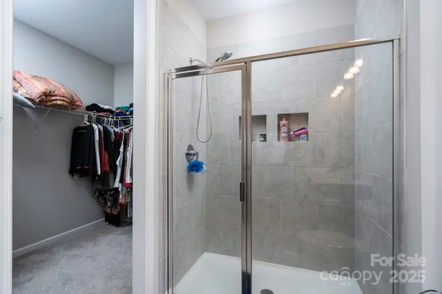 a view of walk in closet with clothes and shoes