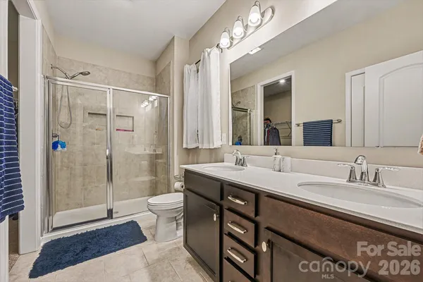 a spacious bathroom with a shower sink mirror and toilet