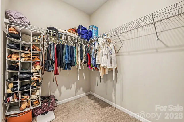 a view of walk in closet with clothes and shoes