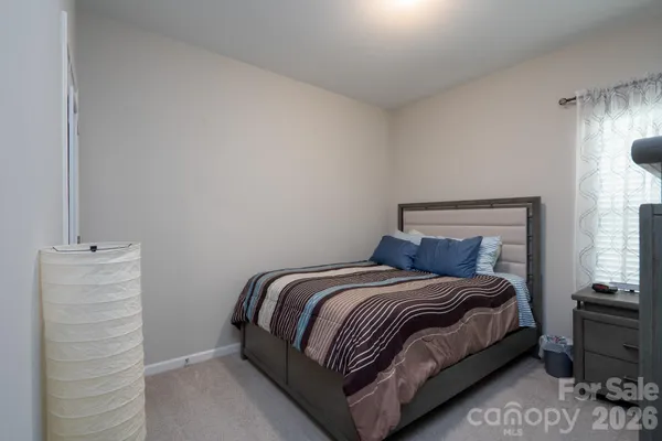 a bedroom with a bed lamp and a window