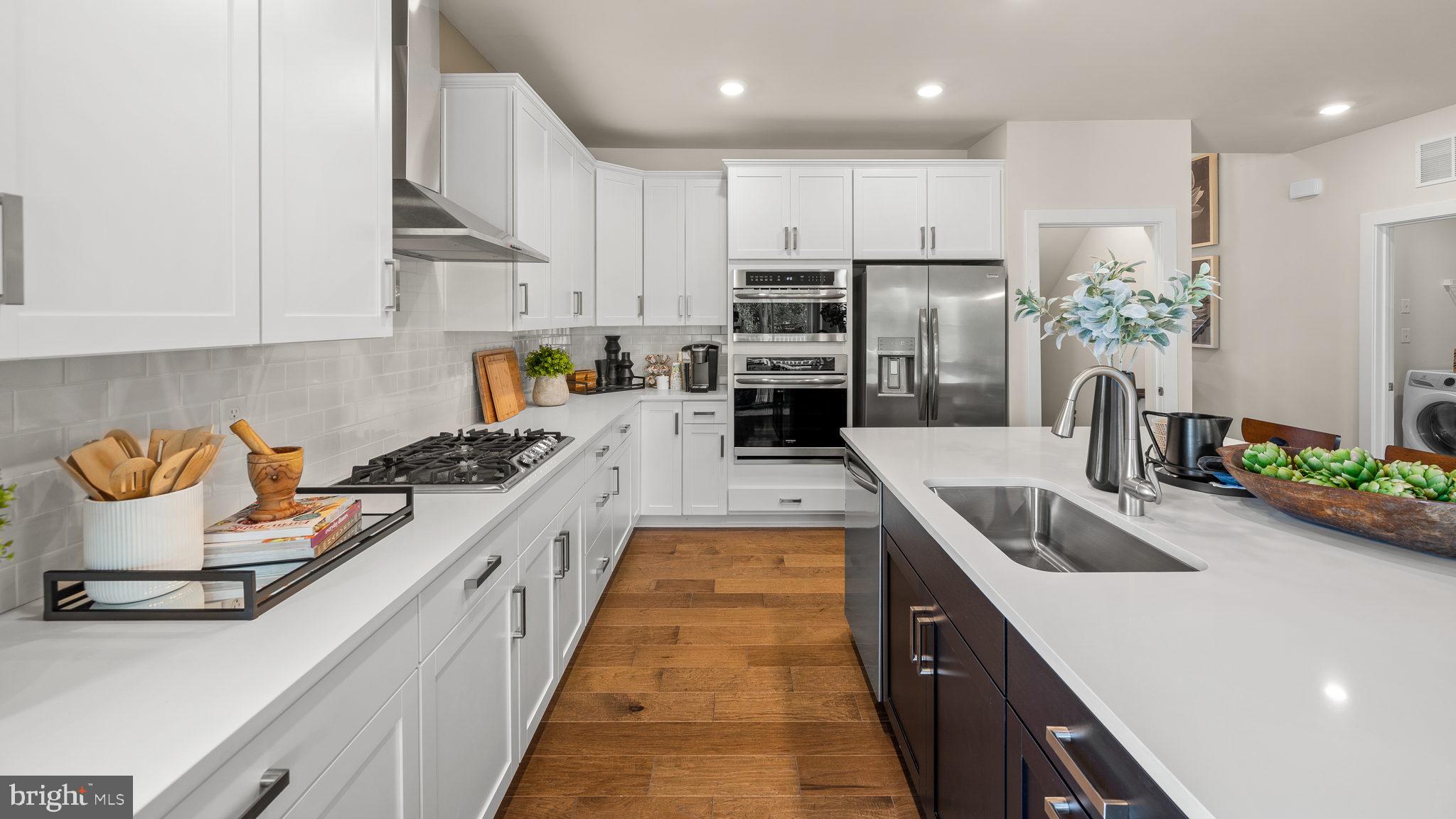 a kitchen with kitchen island granite countertop a sink a counter space and stainless steel appliances