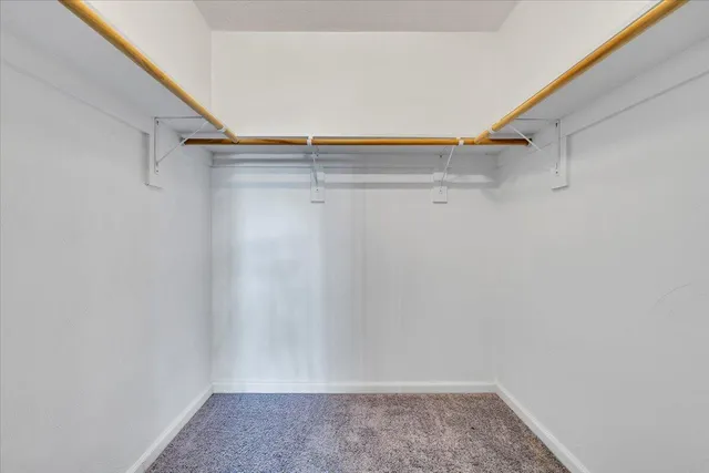 a view of walk in closet with empty racks