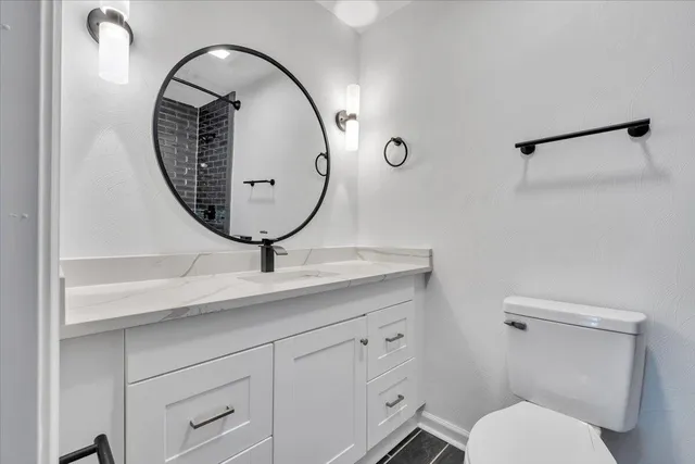 a bathroom with a toilet a sink and a mirror