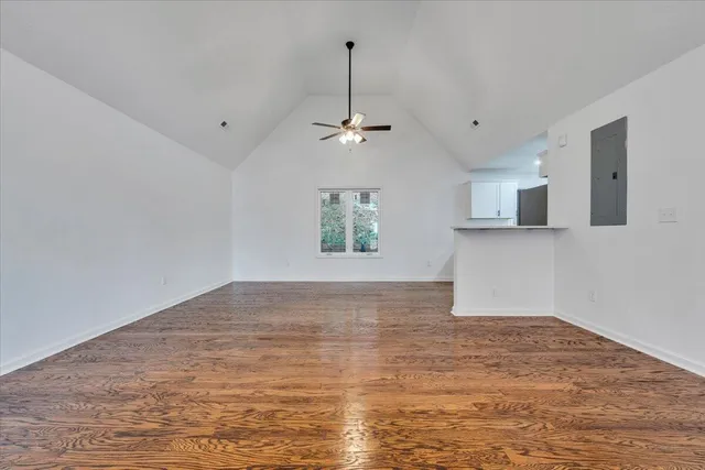 a view of empty room with wooden floor and ceiling fan