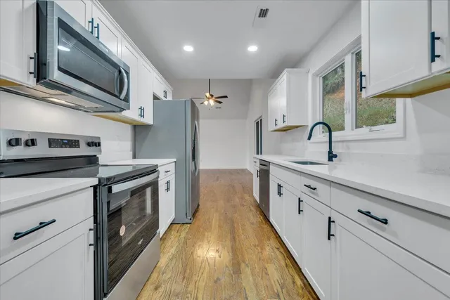 a kitchen with stainless steel appliances granite countertop a sink and a stove