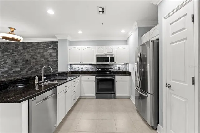a kitchen with stainless steel appliances granite countertop a refrigerator sink and stove