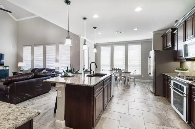 a kitchen with stainless steel appliances granite countertop a sink a stove and a refrigerator