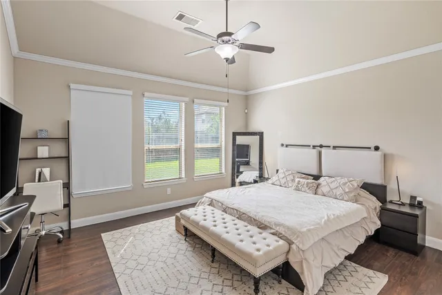 a bedroom with a large bed a chandelier and a window