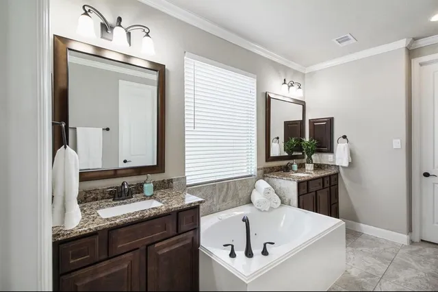 a bathroom with a sink double vanity granite and a mirror