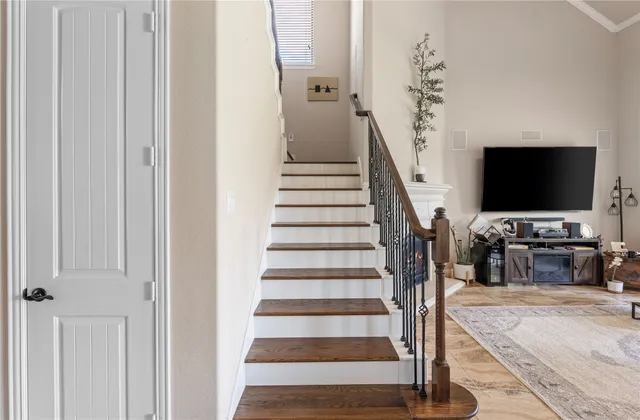 a view of staircase with lots of frames on wall and windows