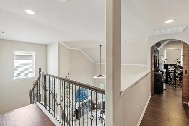 a hallway with wooden floor closet and windows