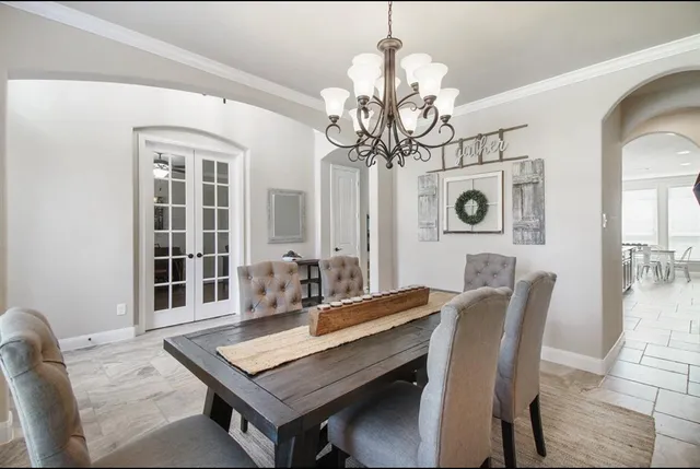 a view of a dining room with furniture a chandelier and wooden floor