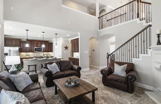 a living room with furniture kitchen view and a wooden floor
