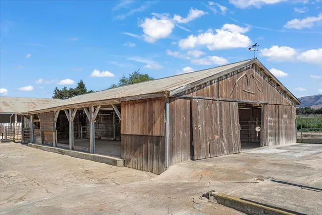 a backyard of a house with wooden fence and large trees